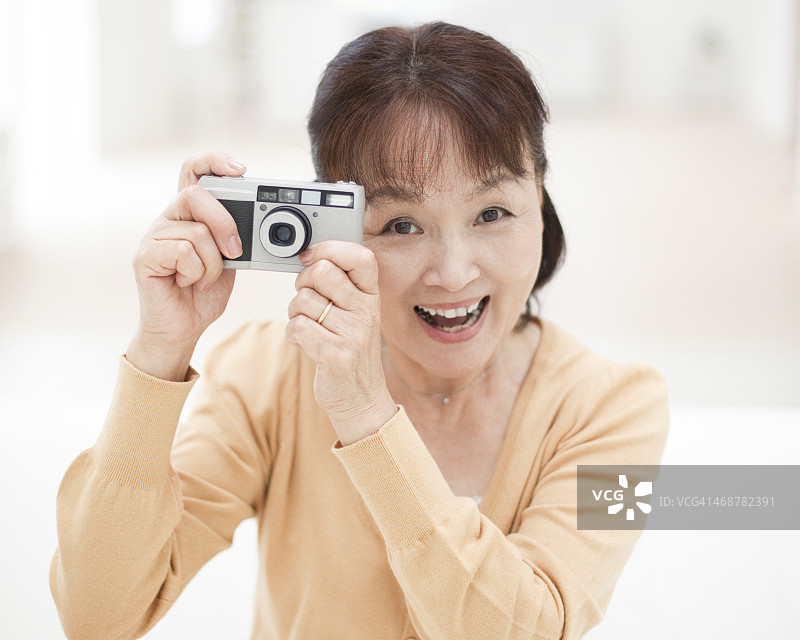 手持相机的年长女性图片素材