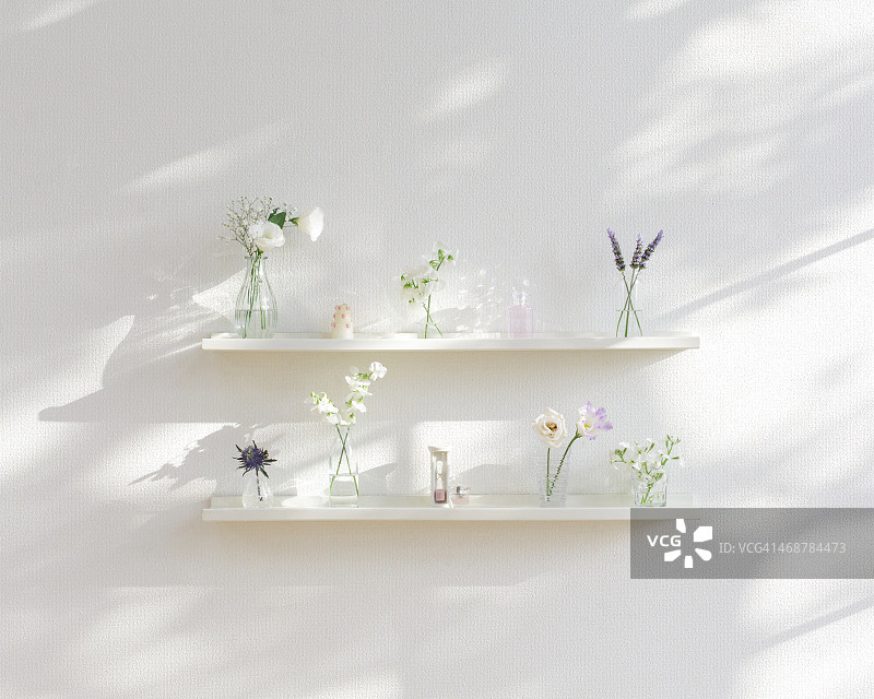 架子上花瓶里的粉彩色花朵图片素材