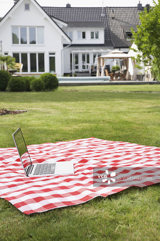 德国科隆：花园里毯子上的笔记本电脑图片素材