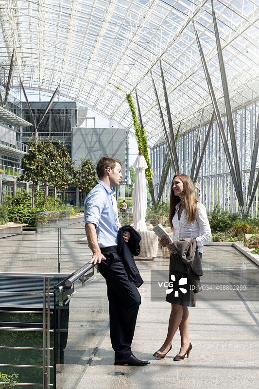 在现代办公楼交谈的商人和女商人图片素材