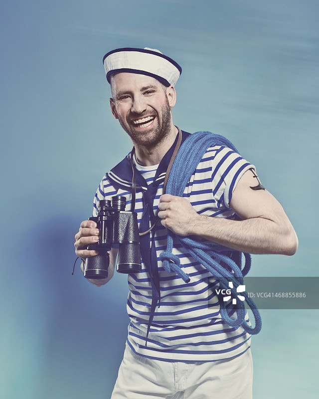 穿着水手服，拿着双筒望远镜的络腮胡男人图片素材