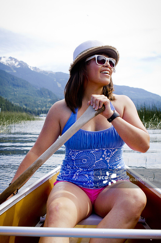 在缓慢的河流中划皮划艇的人图片素材