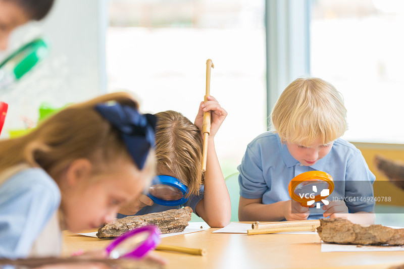 私立小学学生在科学教室使用放大镜图片素材