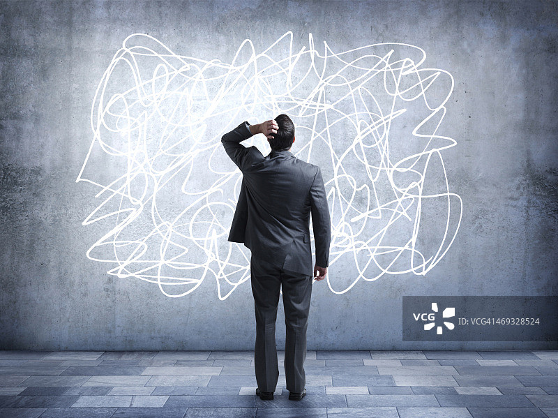 困惑的商人盯着墙上的涂鸦图片素材