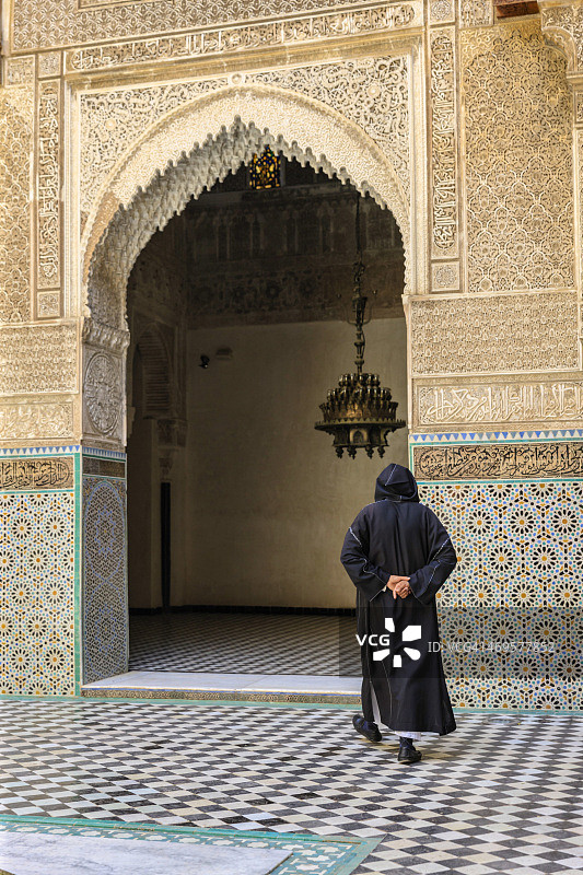 行走在非斯阿塔林伊斯兰学校内的摩洛哥男子图片素材