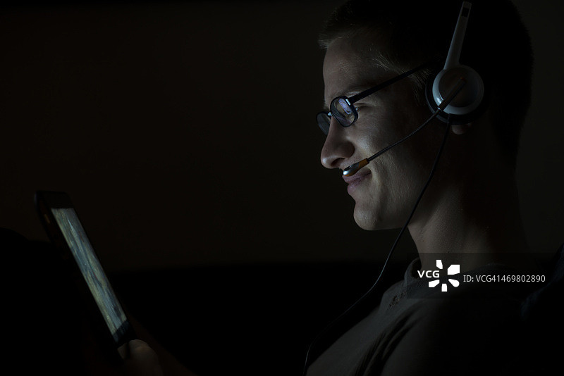 夜晚使用平板电脑的青年图片素材