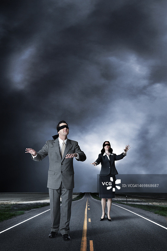 蒙着眼睛的商人和女商人走在高速公路中间图片素材