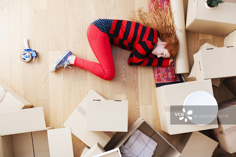 年轻女子拆箱后疲惫不堪，开启新生活图片素材