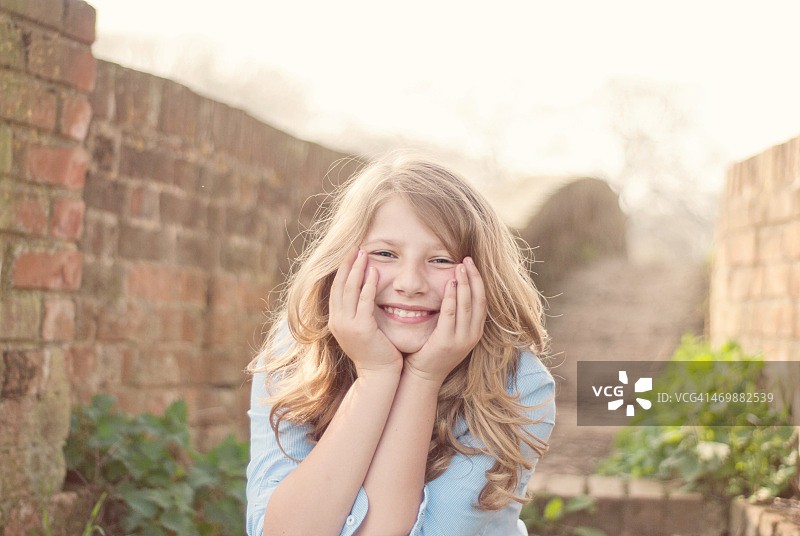 在阳光下微笑的金发女孩图片素材