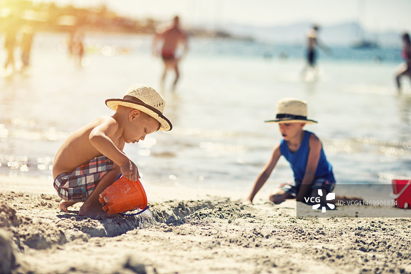 两个男孩在沙滩上玩耍图片素材