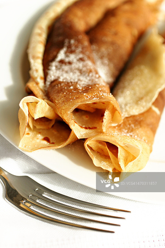 白色盘子上的可丽饼和叉子图片素材