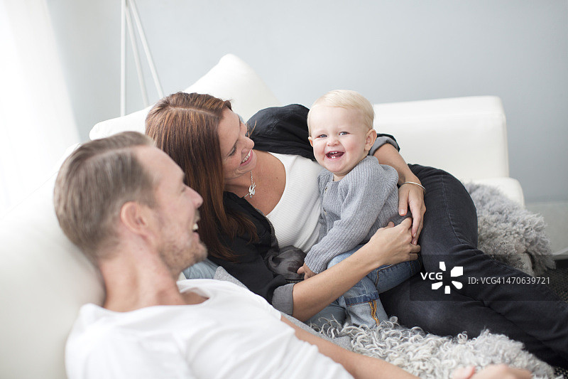 快乐的父母和儿子在沙发上图片素材