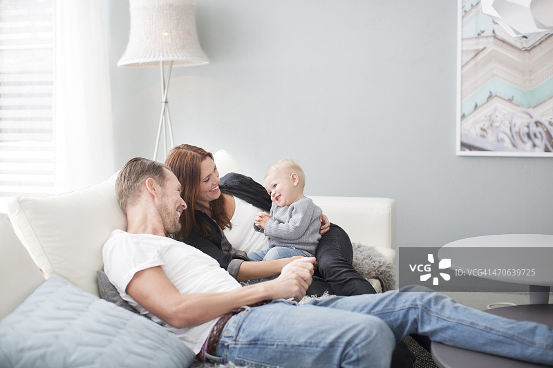 快乐的父母和儿子在沙发上图片素材