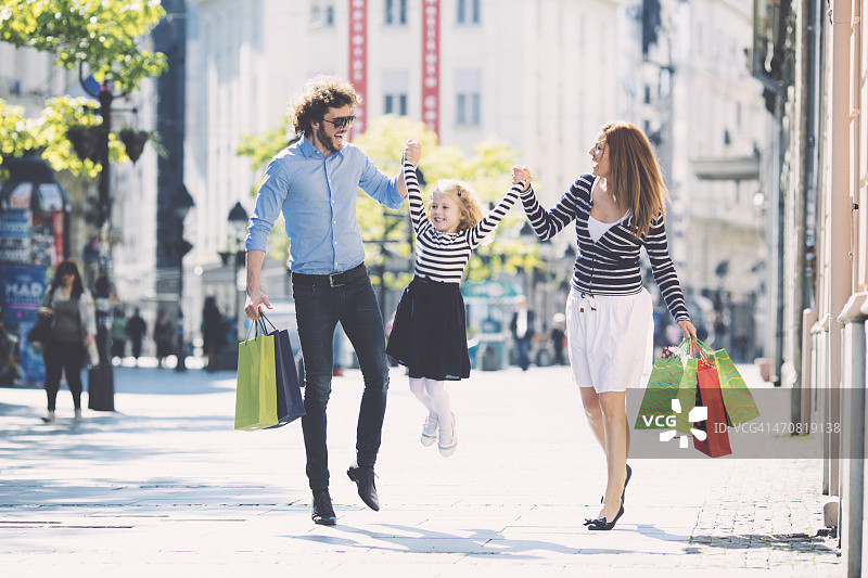 父母和可爱的女儿一起购物图片素材