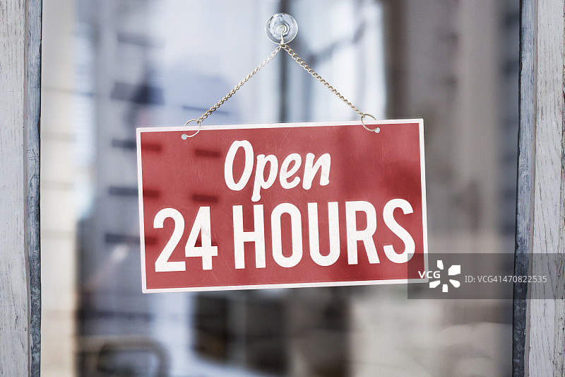 商店玻璃门上的24小时营业标志图片素材