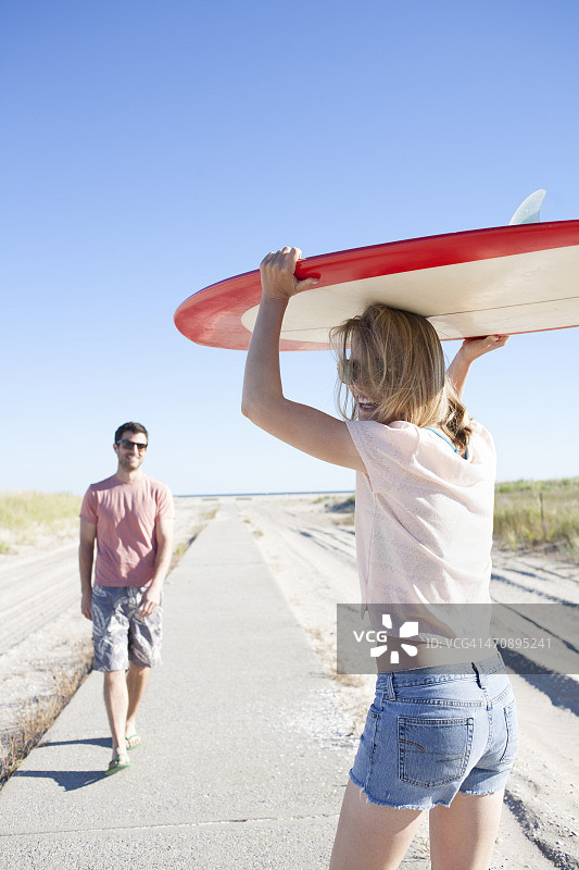 情侣在沿海小路上带着冲浪板图片素材