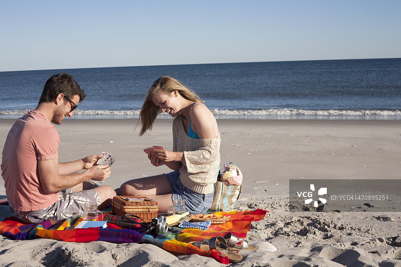 情侣在纽约皇后区微风点海滩玩纸牌图片素材