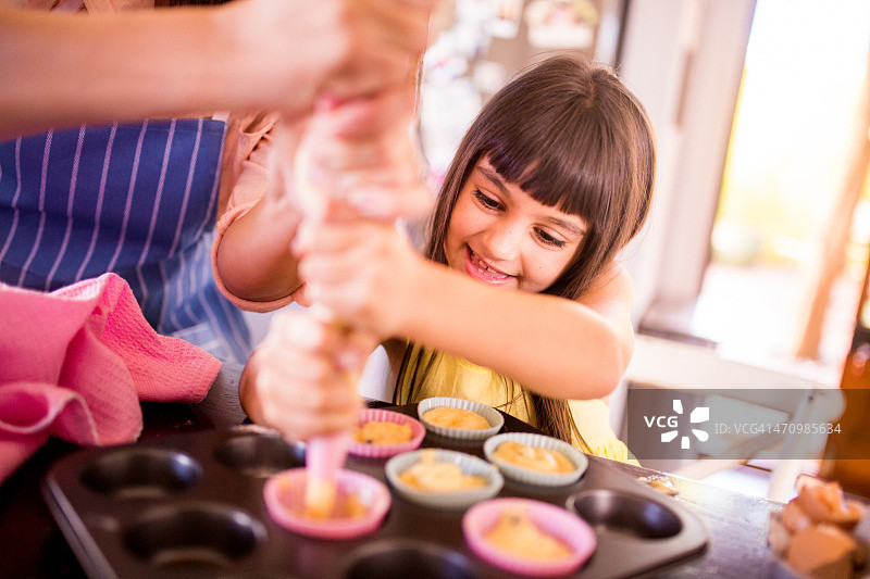 小女孩和妈妈一起做纸杯蛋糕图片素材