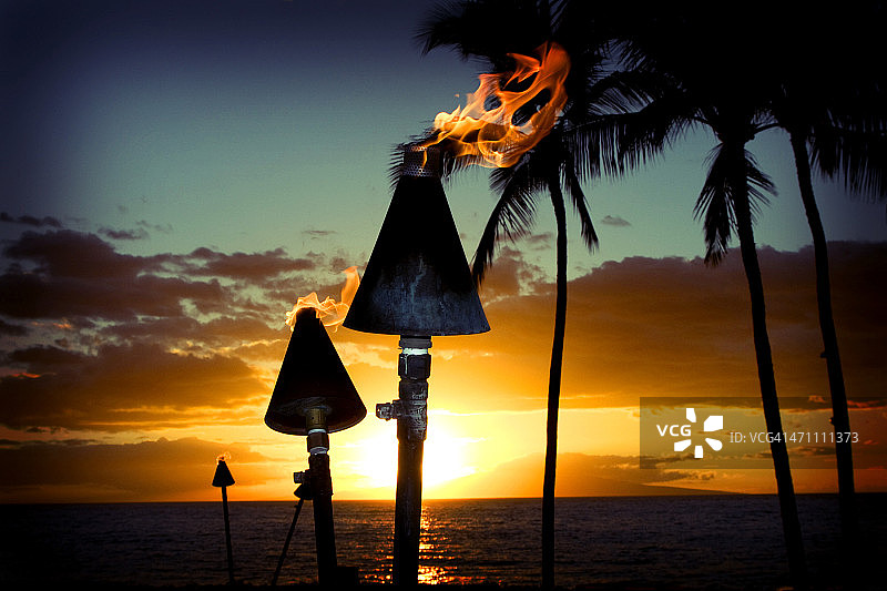美丽岛屿日落背景下的火焰火炬图片素材