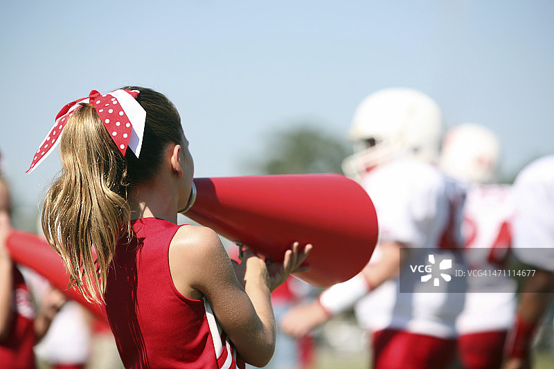 啦啦队员用扩音器为她的足球队欢呼图片素材