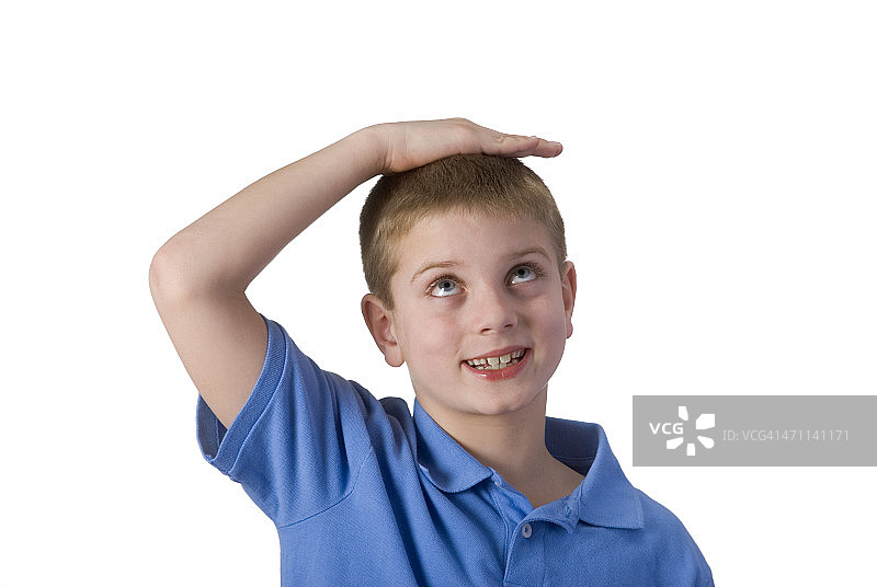 男孩手放在头上测量身高，已抠图图片素材