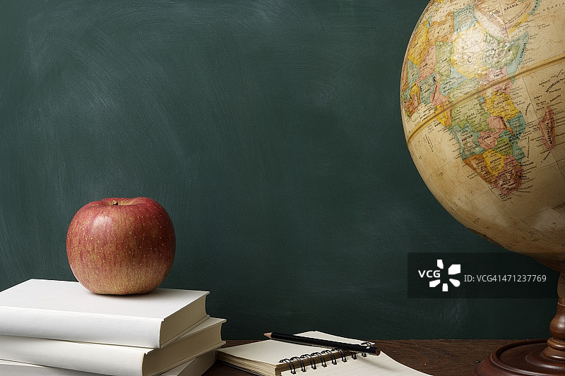 书本上的红苹果和地球仪图片素材
