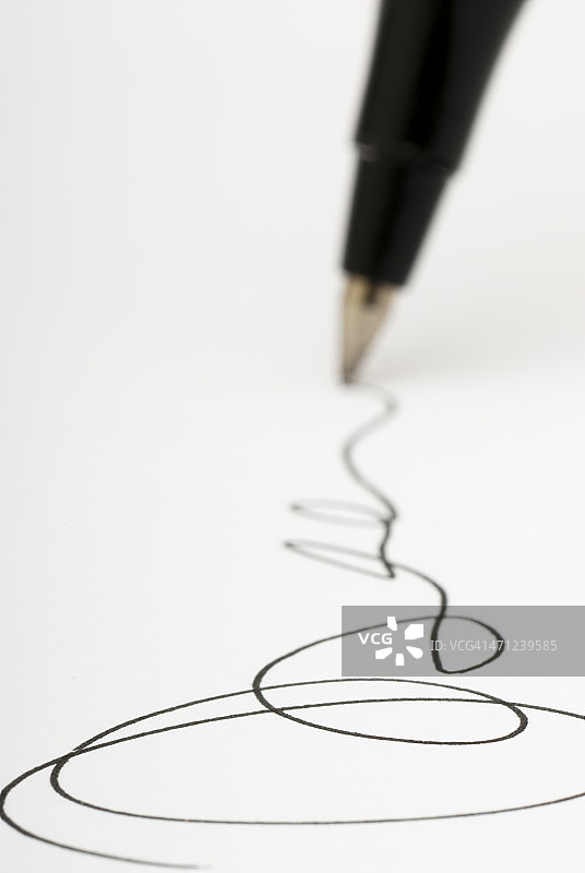 特写镜头的钢笔写签名在白纸上图片素材