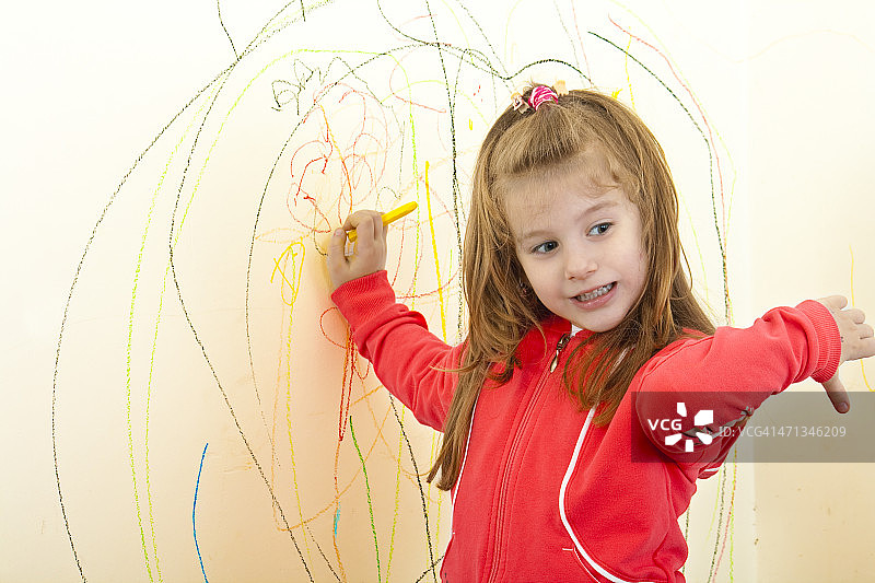 小女孩在墙上绘画图片素材