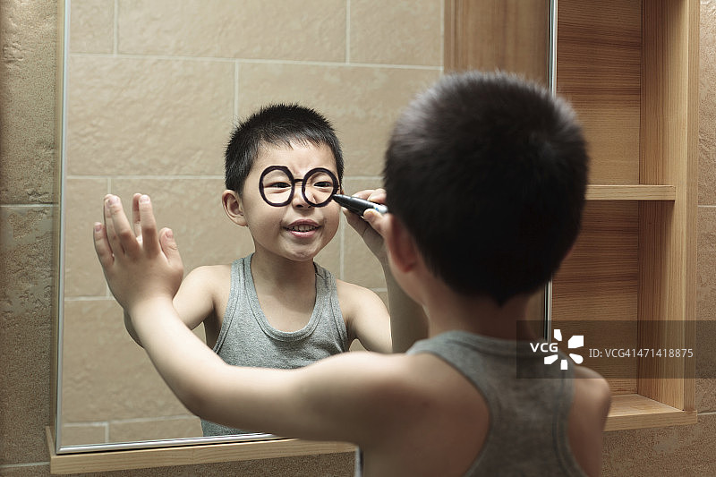 小男孩在浴室镜子上的涂鸦图片素材