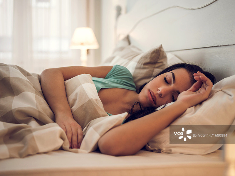 年轻漂亮的女人在卧室里小睡图片素材