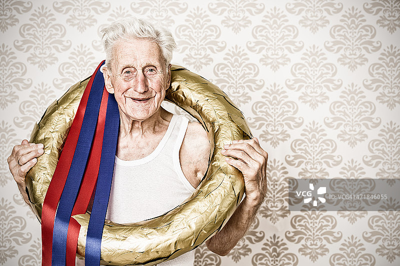 获胜者 - 戴着金色月桂花环的年长男人图片素材