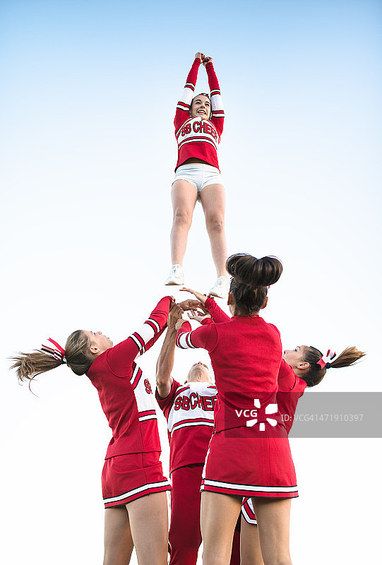 啦啦队队员将一个女孩抛向空中图片素材