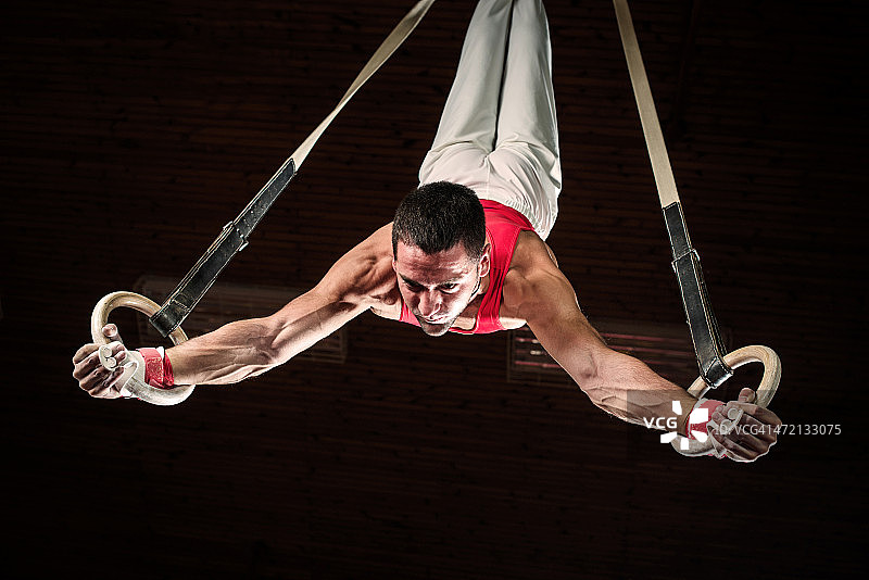 在体操吊环上的男性运动员图片素材