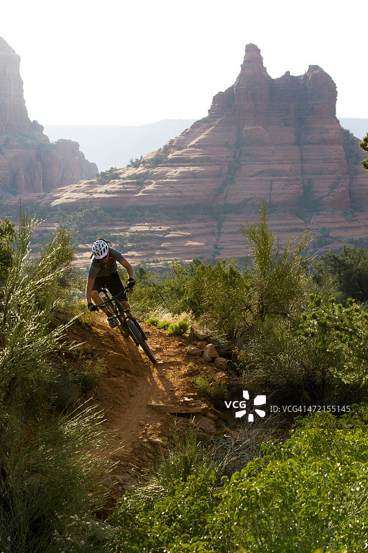 山地自行车手在崎岖的山路上骑行图片素材