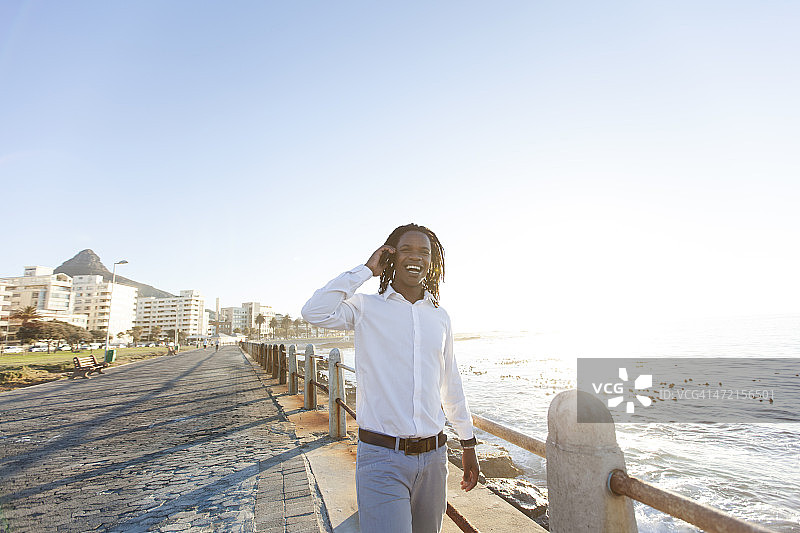 在海滨长廊打电话的非洲裔商人图片素材