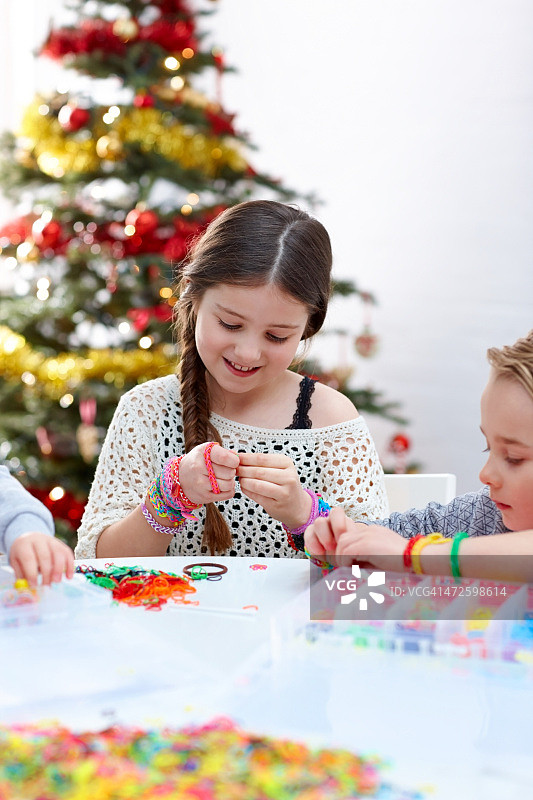 小女孩和朋友制作编织手链图片素材