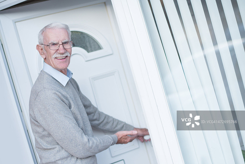 退休老人打开家门图片素材