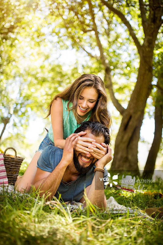 笑着遮住男友眼睛的女孩图片素材