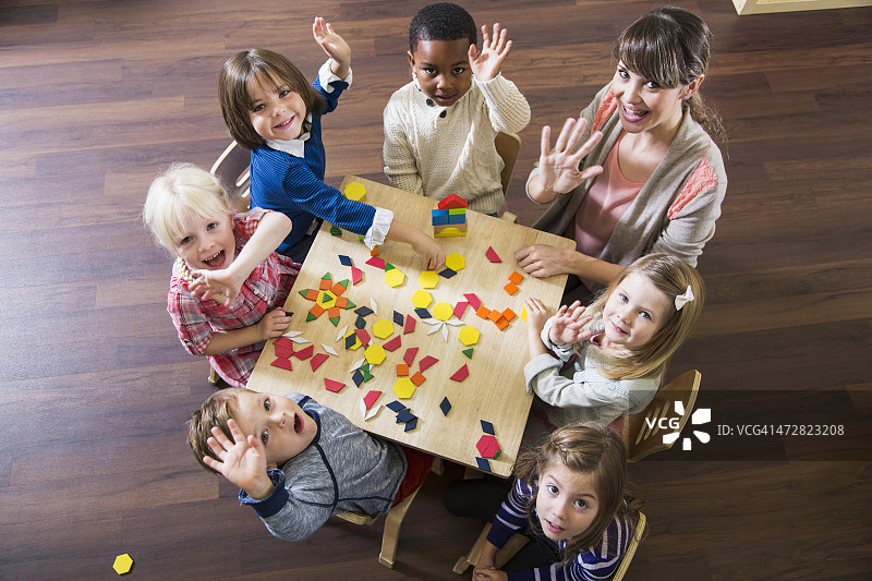老师和学龄前儿童玩彩色形状玩具图片素材