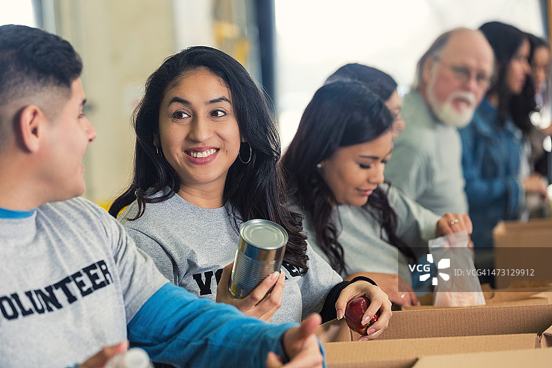 志愿者们将食物分类到纸板箱中，用于慈善图片素材