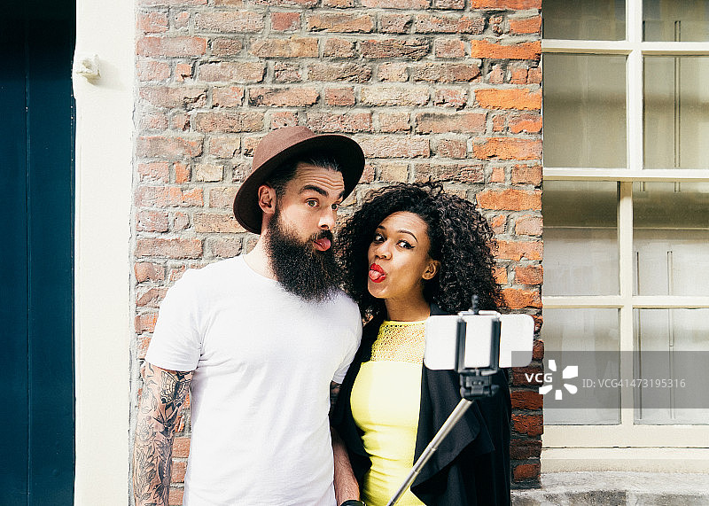 男人和女人用自拍杆自拍图片素材