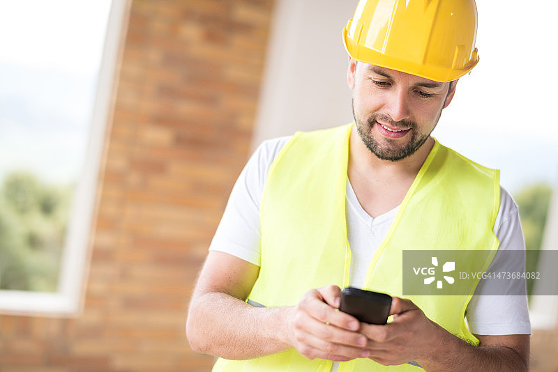 建筑工人用手机发短信图片素材