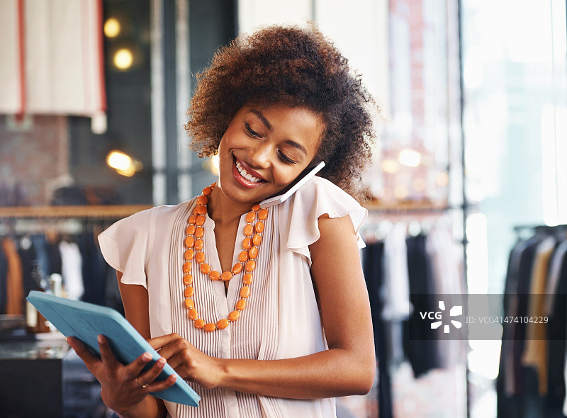 使用数位平板电脑并打电话的女人图片素材