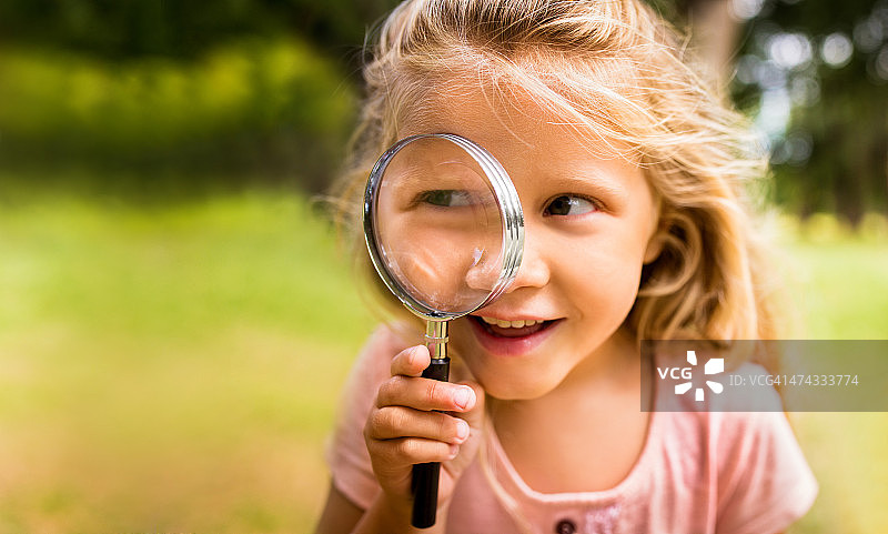 探索：拿着放大镜的女孩与大自然图片素材