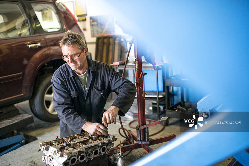 修理工在车库修理汽车零件图片素材