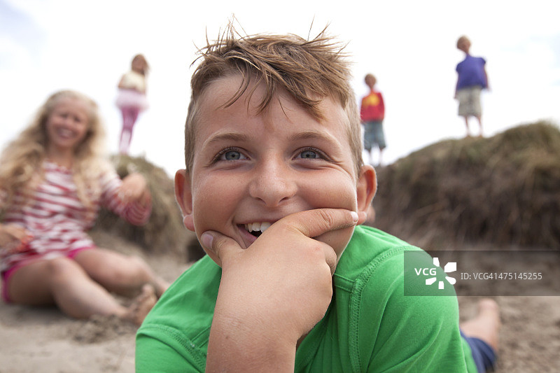 手托着下巴微笑的男孩，威尔士，英国图片素材