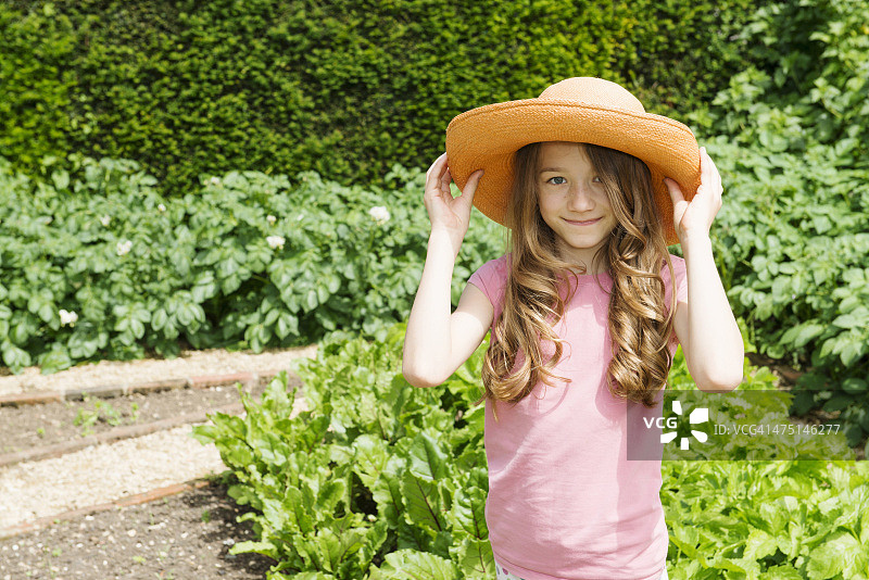 在花园里戴着草帽的女孩图片素材