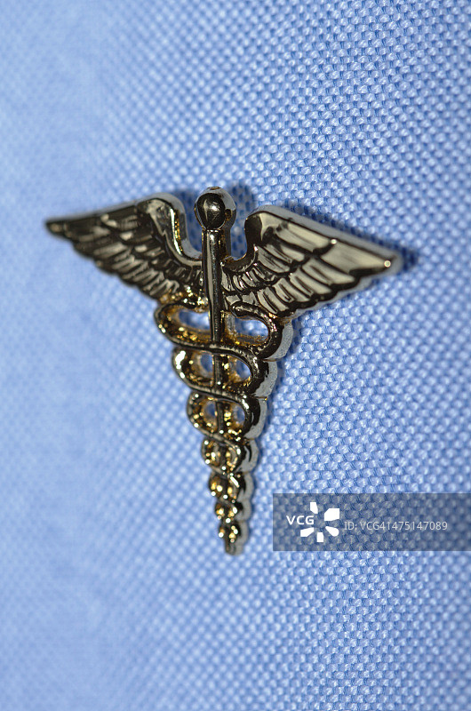 别在衬衫上的医疗双蛇杖徽章图片素材