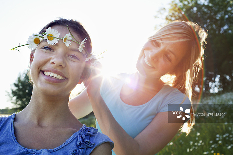 母亲为女儿编织雏菊头环图片素材