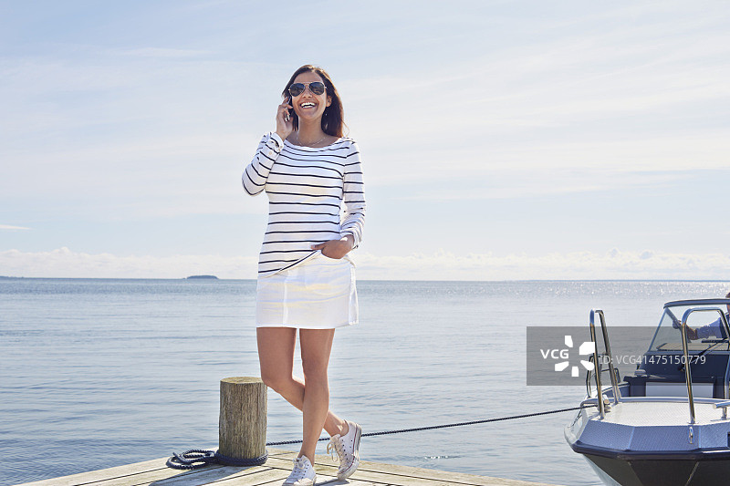 在瑞典耶夫勒码头上用手机的年轻女子图片素材